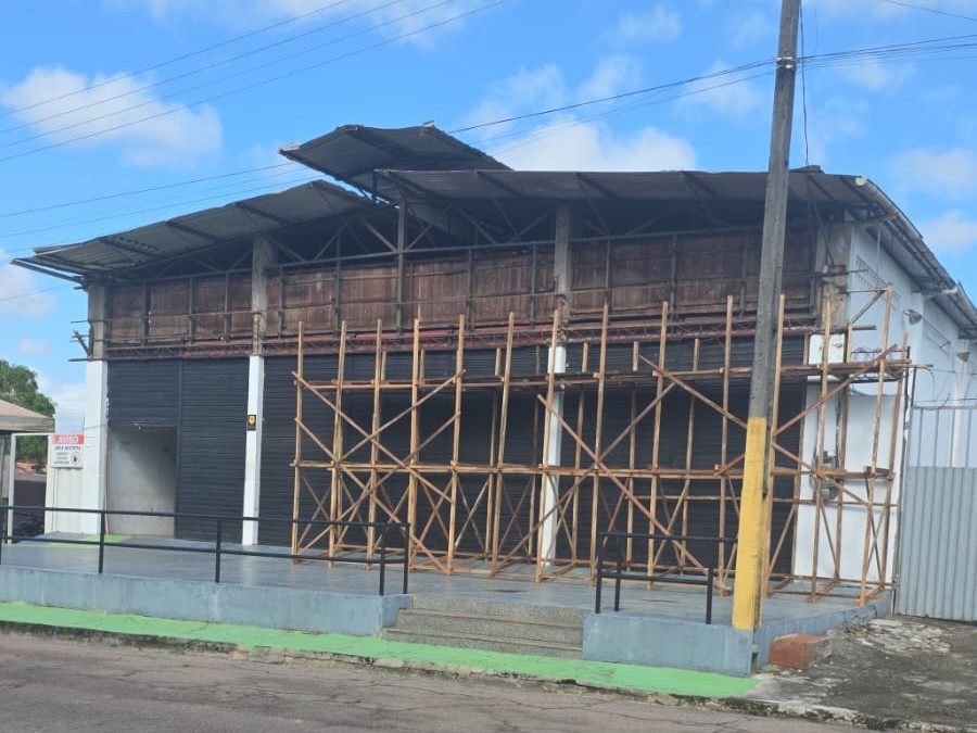 Fachada de galpão comercial com estrutura de andaime de madeira montada para serviços de manutenção e inspeção predial na Brasil Mar em Barcarena.