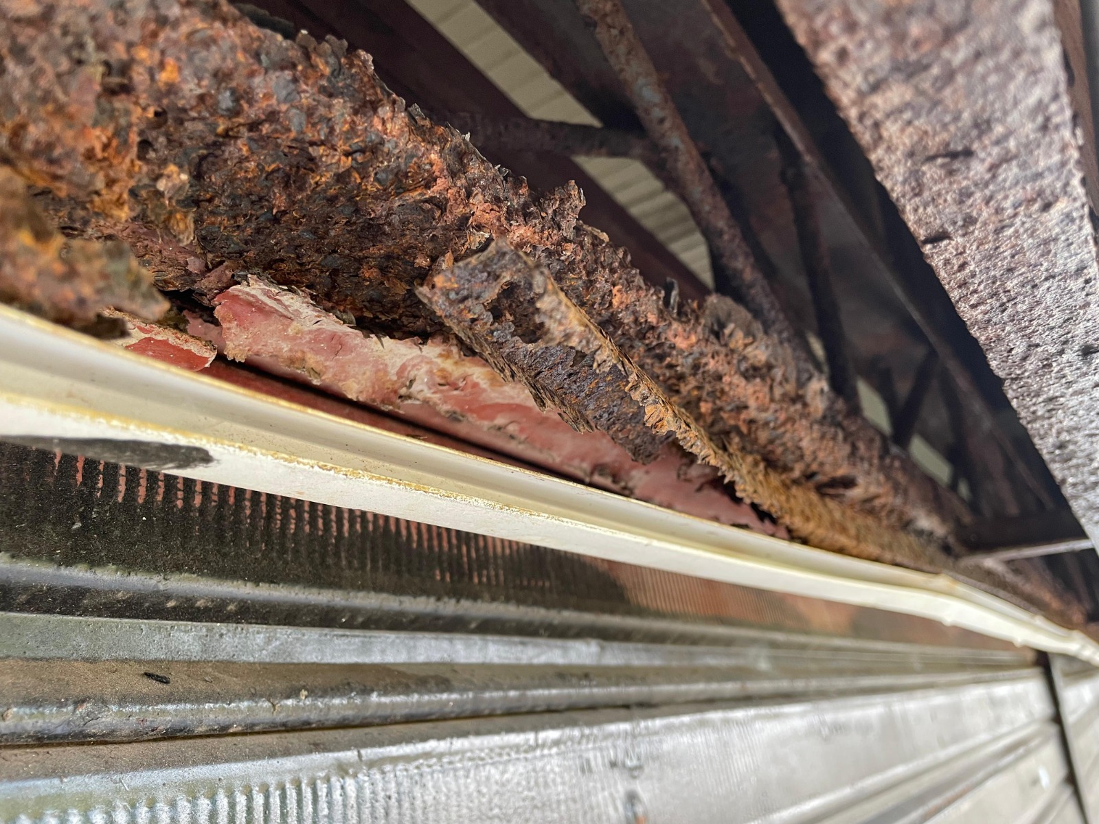 Close técnico de viga metálica com corrosão severa e desplacamento de ferrugem, identificada durante inspeção predial em galpão comercial em Barcarena.