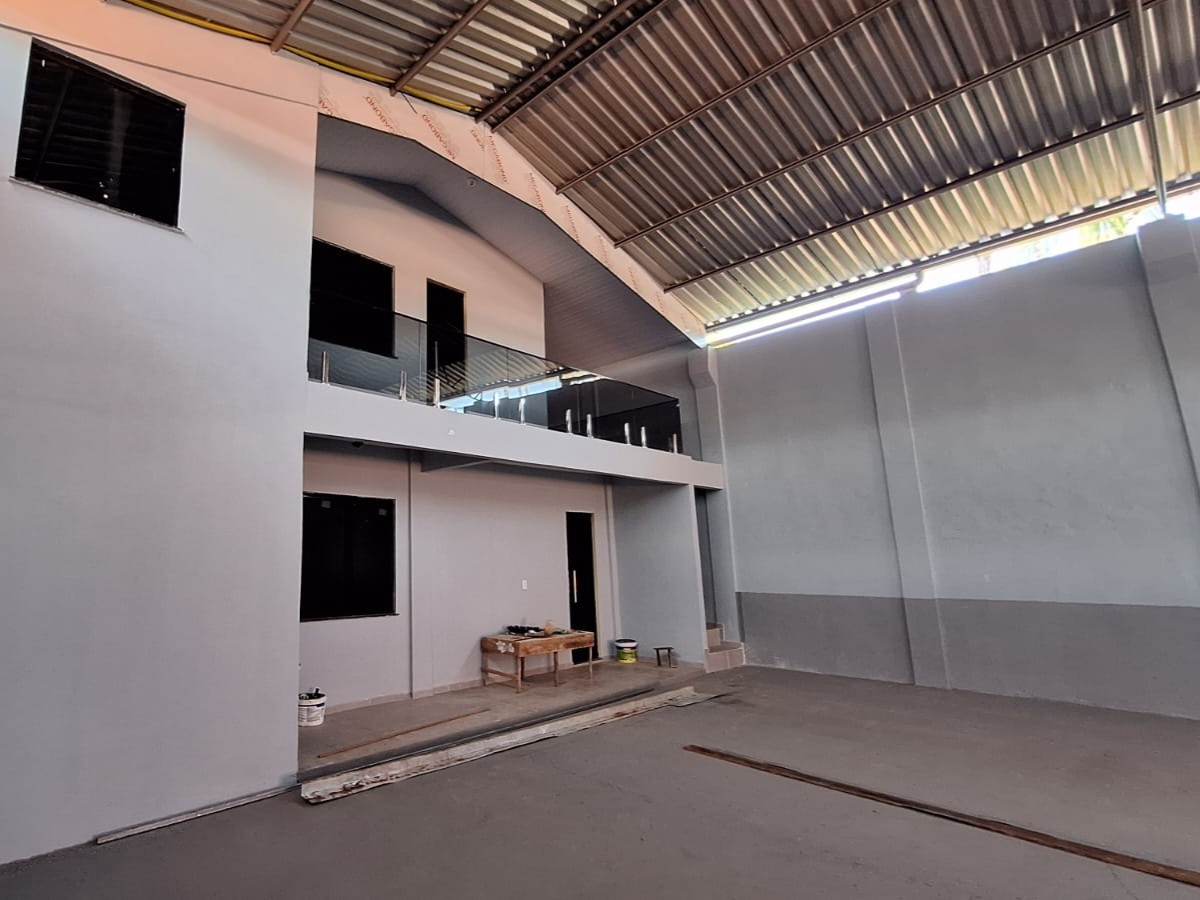 Vista interna de galpão comercial finalizado em Barcarena, mostrando área de escritório com dois pavimentos, guarda-corpo de vidro fumê e cobertura metálica de zinco.
